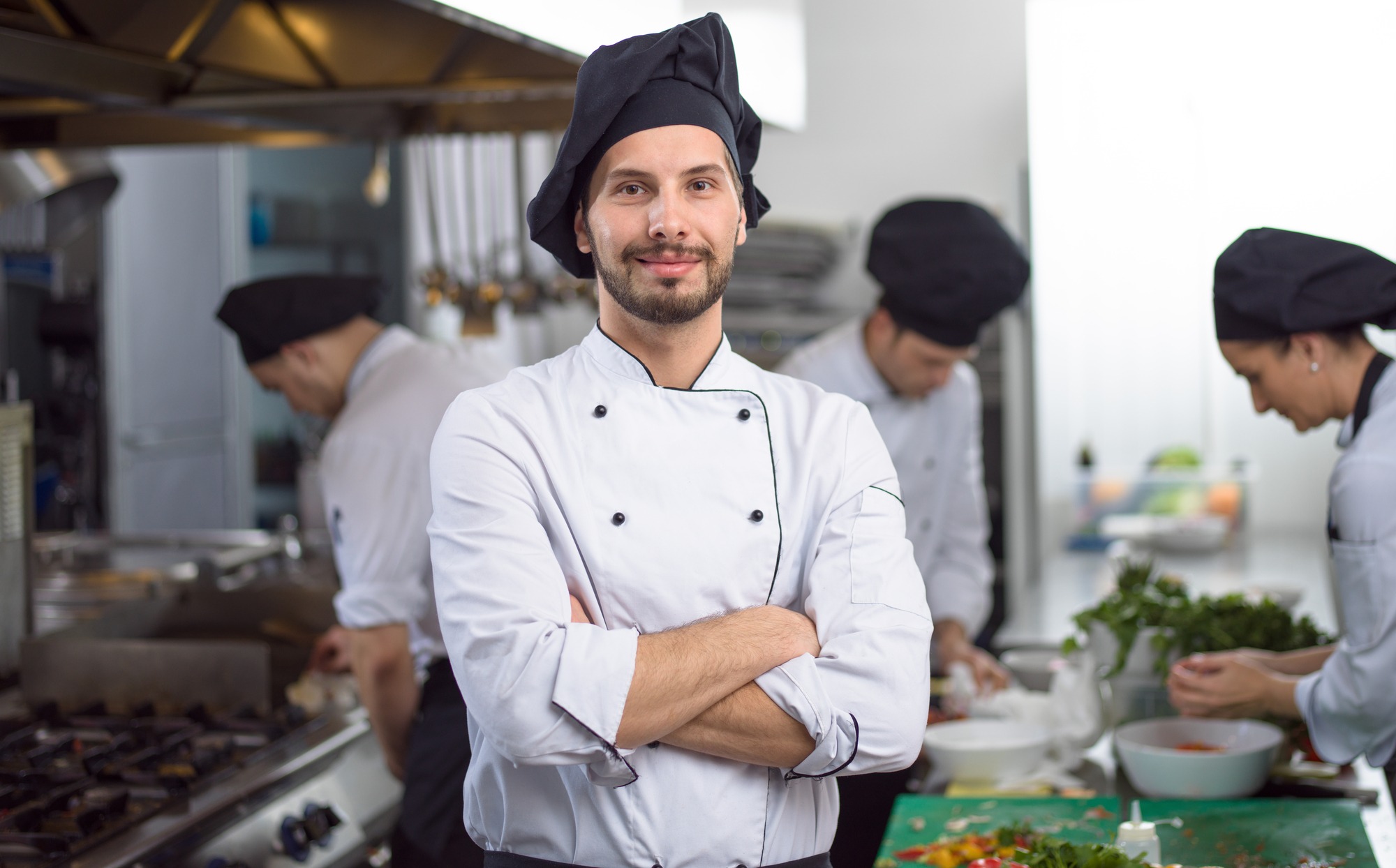 Portrait of Young Chef Standing in Commercial Kitchen at Restaurant.